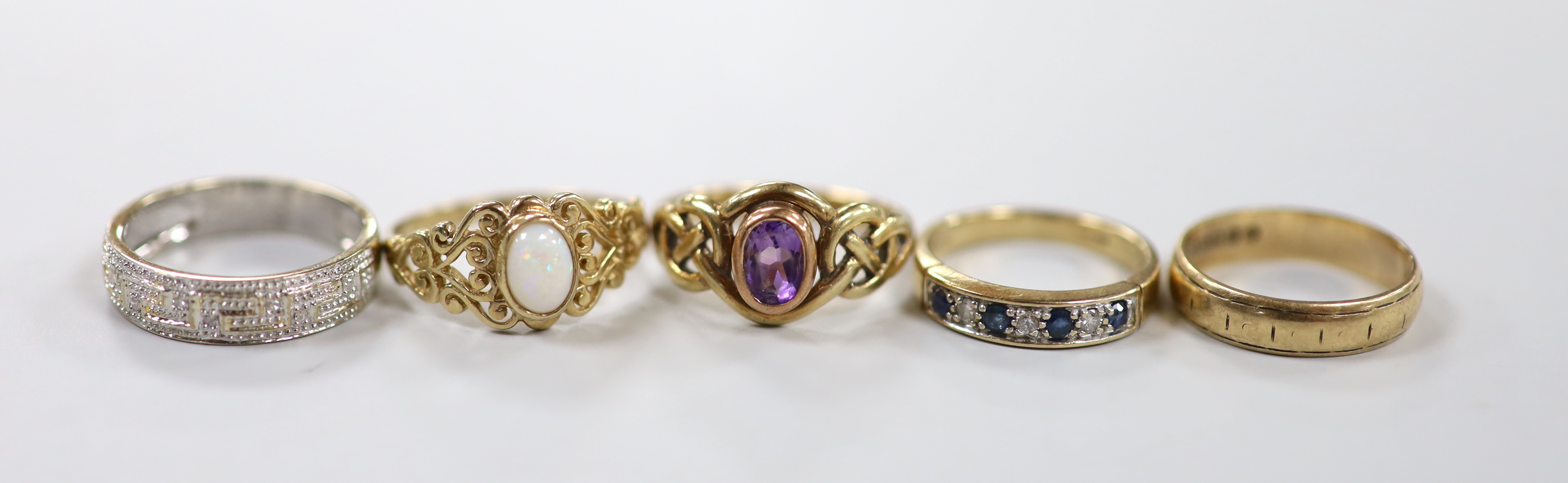 Four assorted modern 9ct gold and gem set dress rings, including single stone amethyst and singe stone white opal, together with a 9ct gold band, gross weight 13.5 grams.